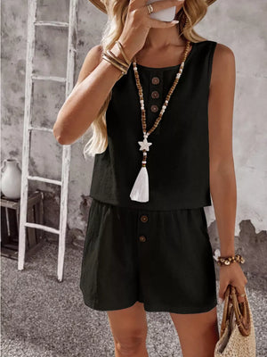 Black cotton two-piece set with decorative buttons and tassel necklace.