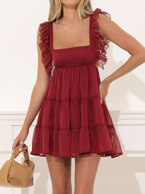 Brick red ruffled square neck mini dress with tiered skirt and sheer ruffle straps.