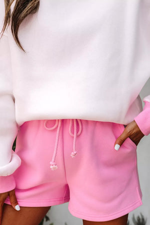 White sweatshirt with pink trim and pink cotton drawstring shorts