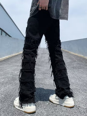 Black distressed slim fit jeans with frayed detailing on the legs.