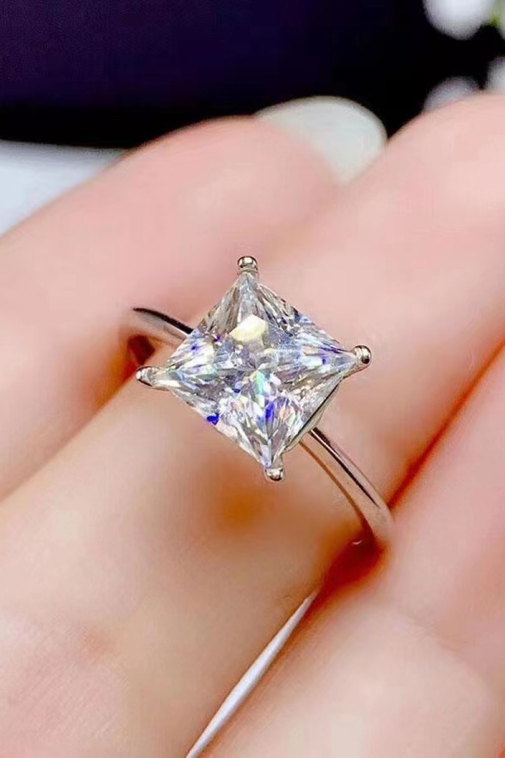 Silver ring with a bright princess-cut solitaire diamond.