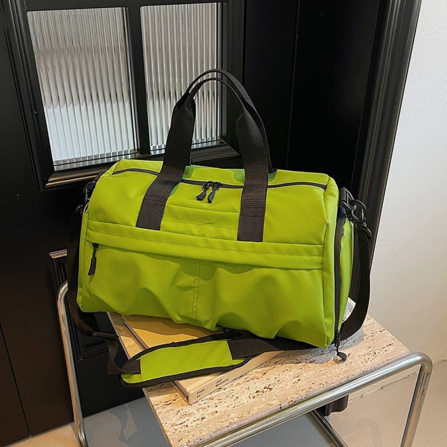 Green nylon travel duffel bag with black straps and zippers, featuring multiple compartments.