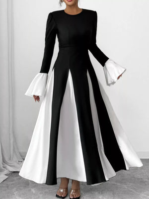 Black flare sleeve maxi dress with contrasting white panels and a flowing skirt.