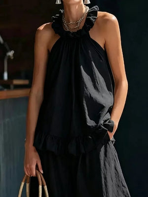 Black ruffled halter neck top with wide-leg pants set, featuring frill details.