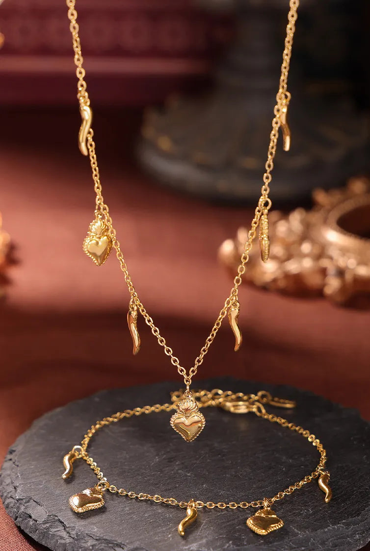 Gold charm jewelry set with sacred heart and horn pendants, 18K gold-plated