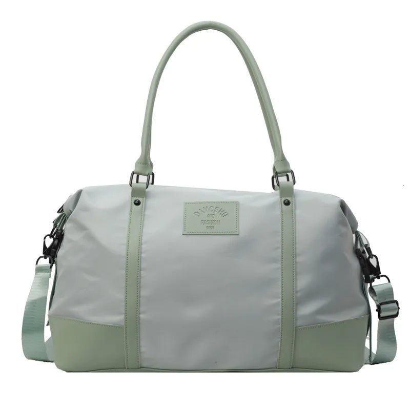 Duffel bag in light gray with sage green accents and strap, featuring a leather patch detail.