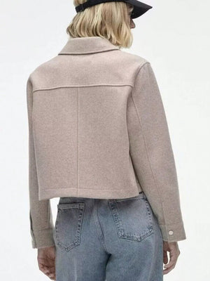 Beige trucker jacket with collar, long sleeves, and snap buttons, styled with jeans.