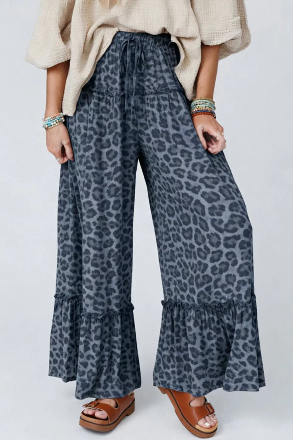Leopard print maternity pants in dark navy with ruffled wide legs and drawstring waist.