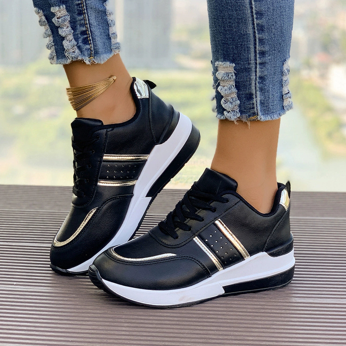 Black lace-up sneakers with metallic accents and a chunky white sole.