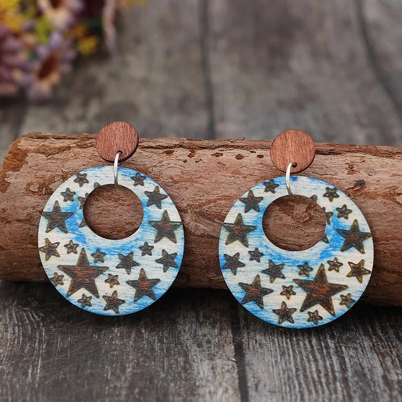 Multicolor celestial starburst wood hoop earrings with a boho pattern.