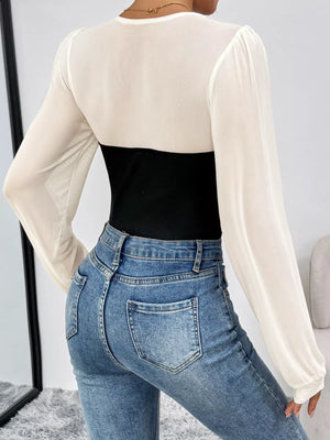 Black and white long-sleeve mesh bodysuit with ribbed black panel, styled with jeans.