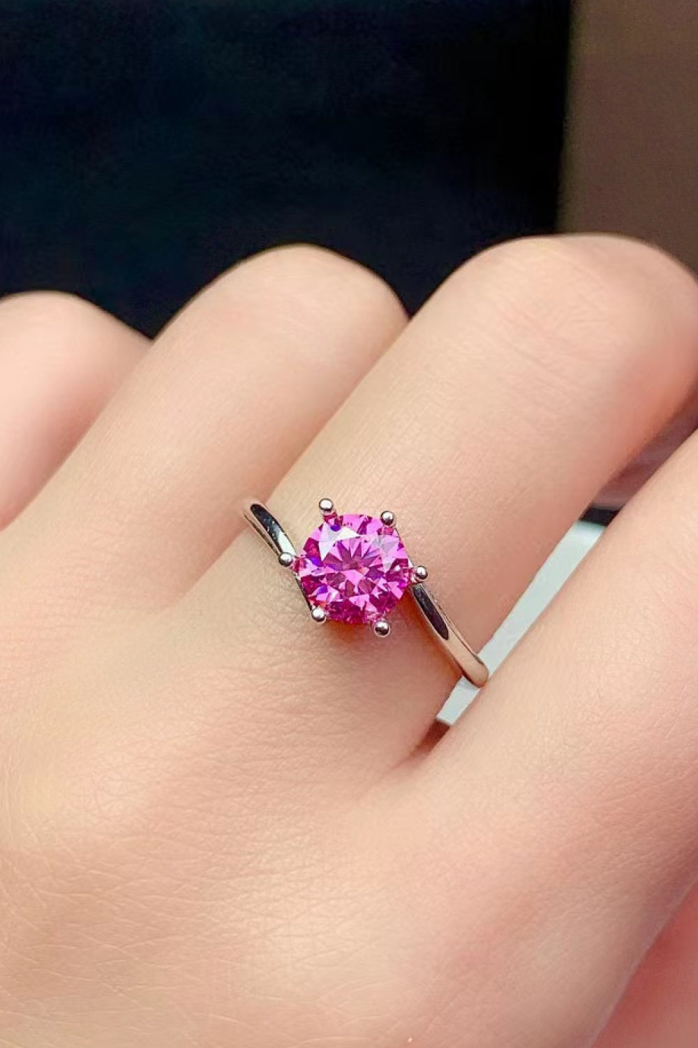 Radiant pink moissanite solitaire ring with a silver band.