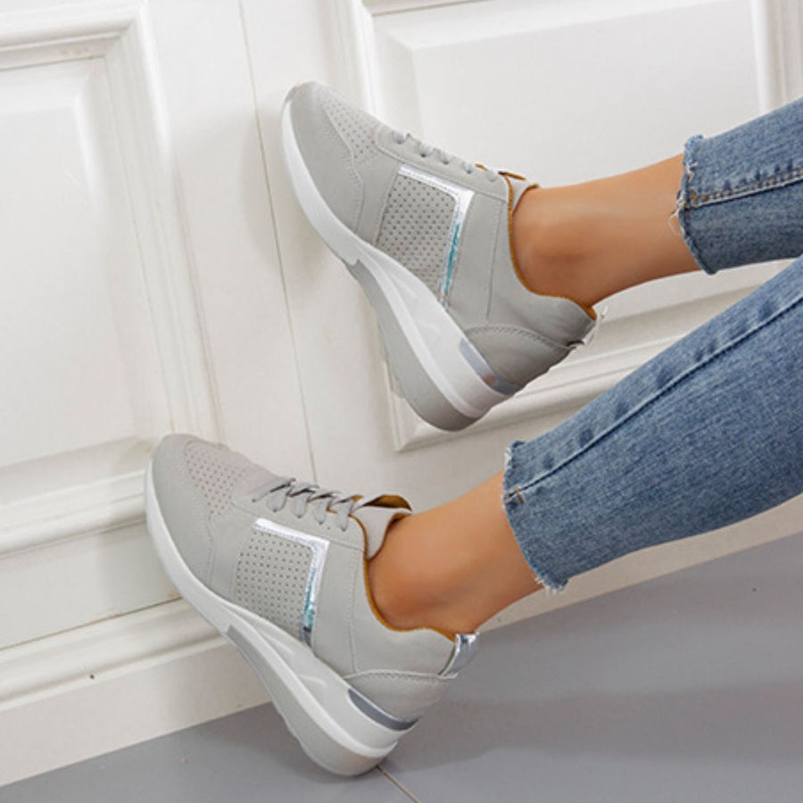 Grey lace-up wedge sneakers with metallic accents and perforated detail.