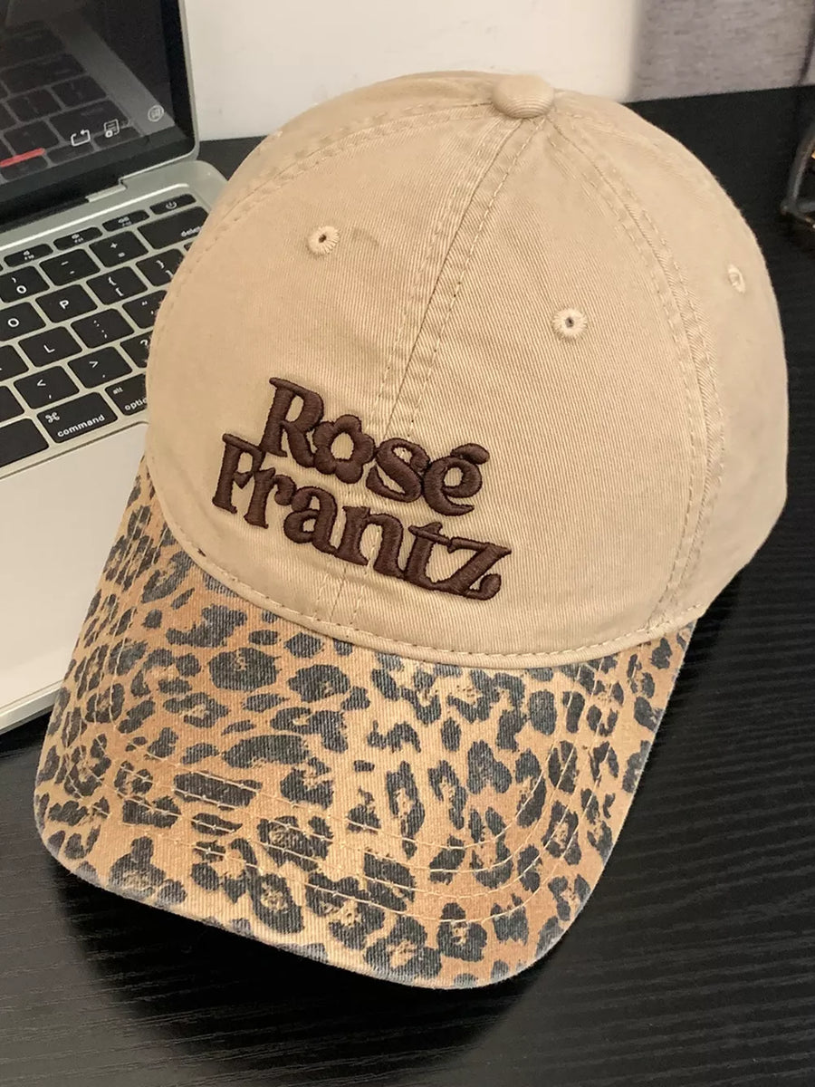 Tan cotton baseball cap with leopard print brim and embroidered text.