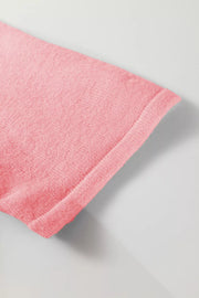 Pink acrylic knit cardigan with a textured weave and cuffed hem detail.