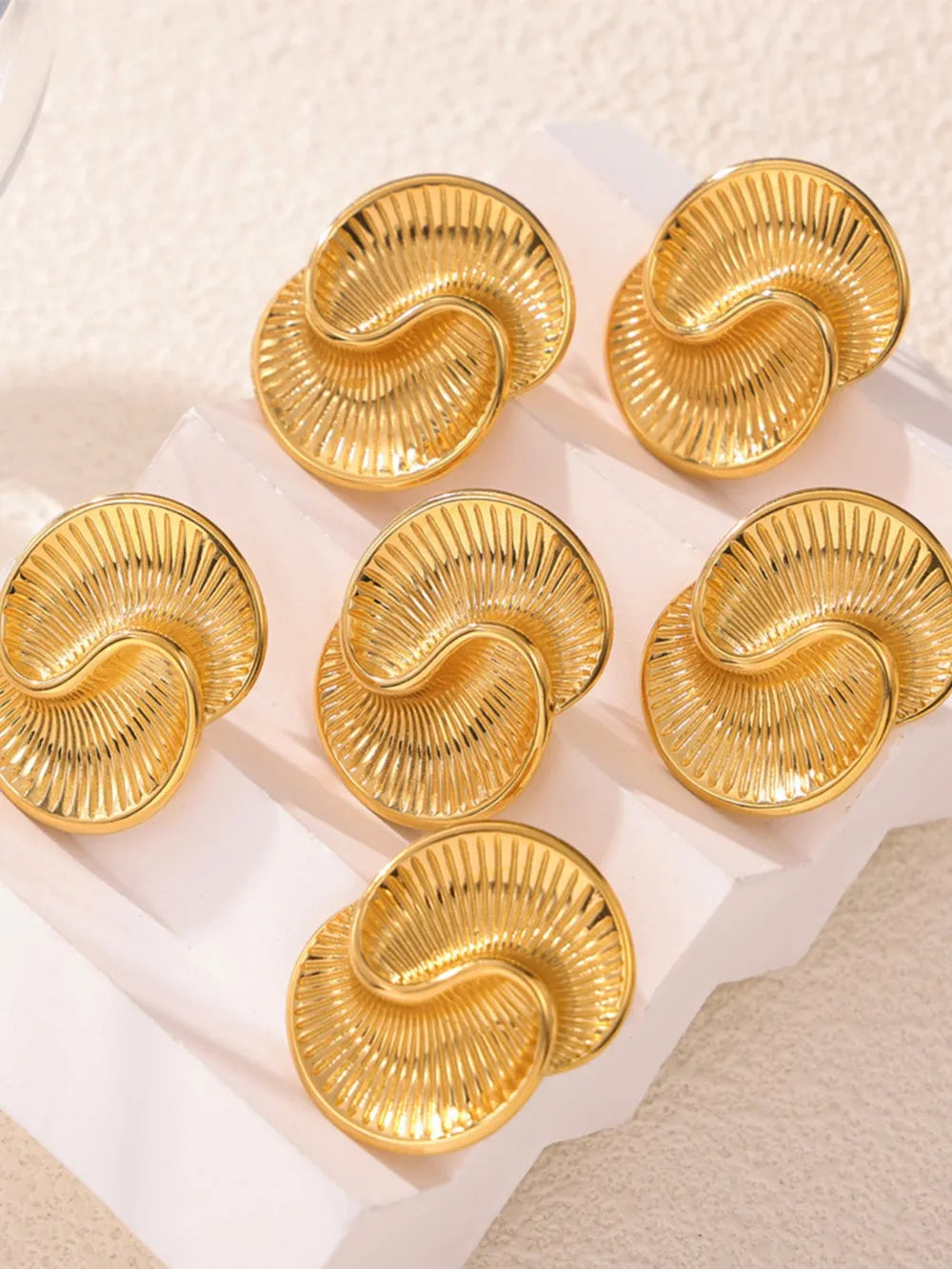 Gold vermeil shell stud earrings with sculpted ribbed detail.