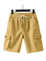 Yellow textured drawstring cargo shorts with button flap pockets.