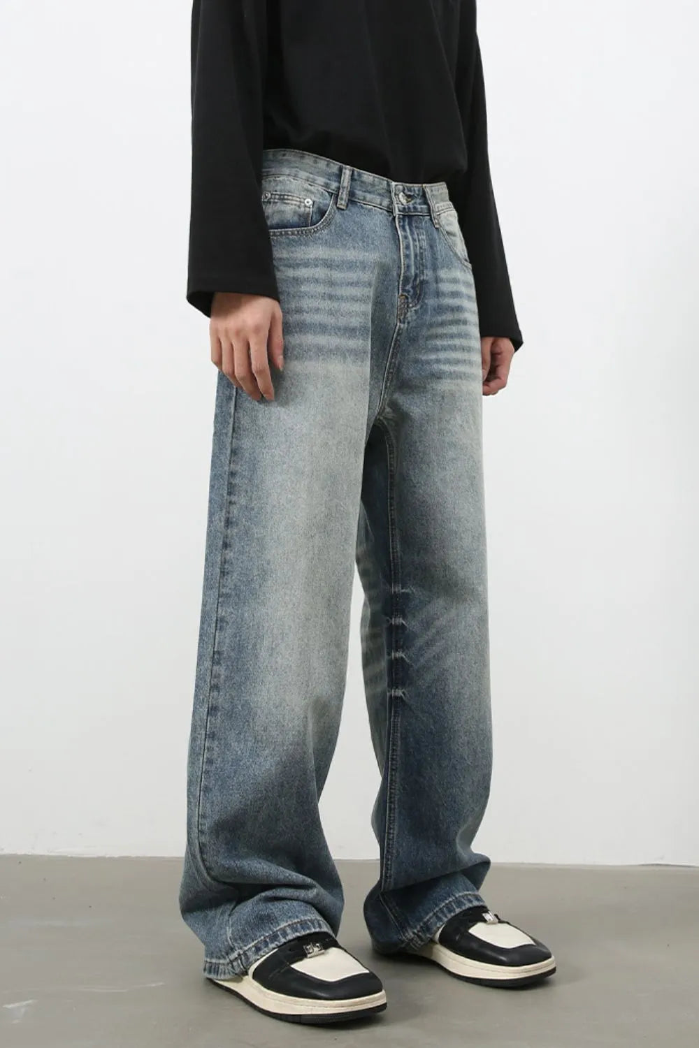 Baggy wash denim jeans in medium blue with a relaxed fit and faded details.