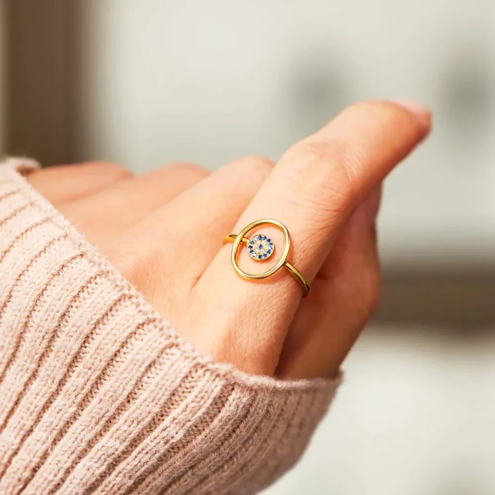 Gold oval ring with blue evil eye detail.
