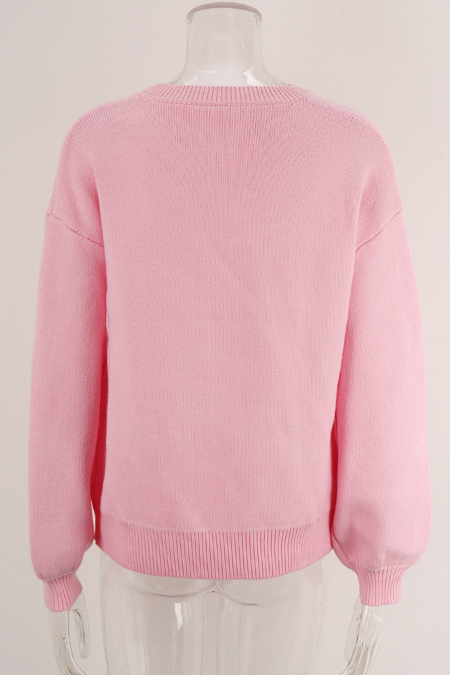 Blush pink acrylic knit sweater with graphic bow intarsia detail and crew neck.