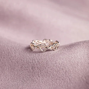 Sterling silver ring with intertwined heart motif, delicate and classic design.