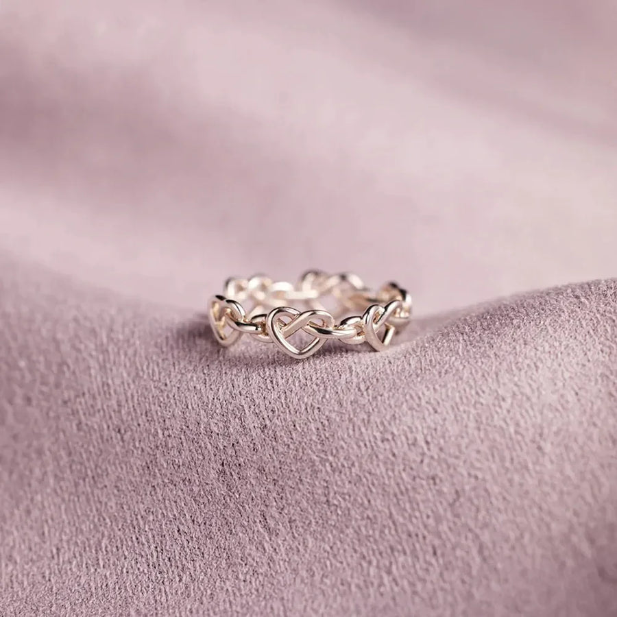 Sterling silver ring with intertwined heart motif, delicate and classic design.
