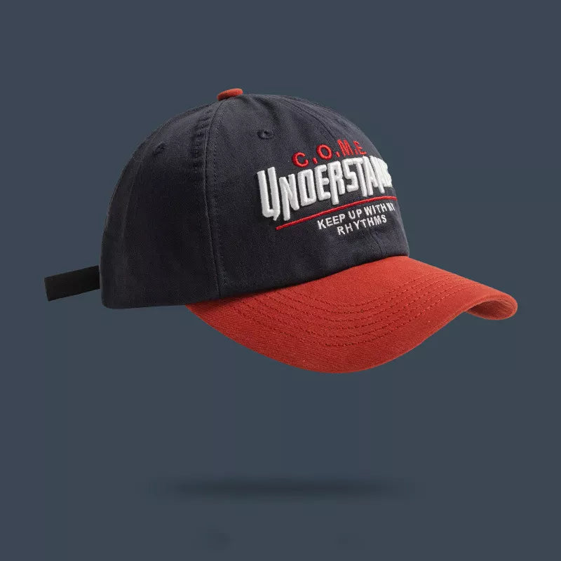 Embroidered baseball cap in navy with red brim and "UNDERSTAR" text detail.