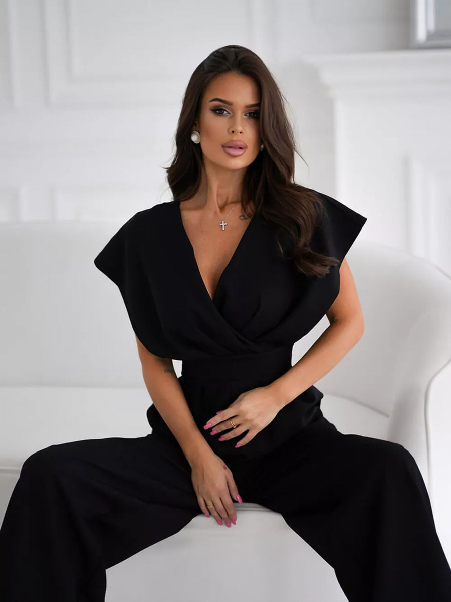 Black surplice wide-leg romper with deep V-neck and cap sleeves.