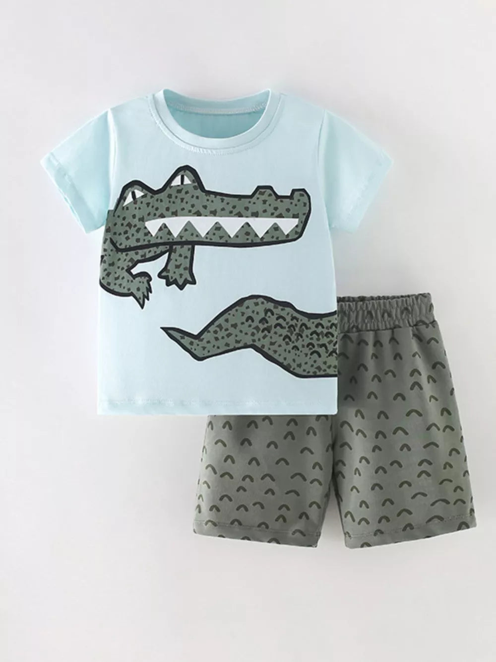 Light blue cotton toddler tee with crocodile graphic and grey shorts with arc pattern.