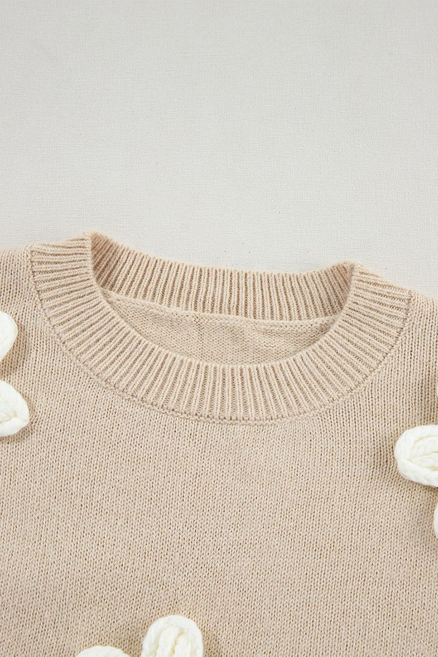 Tan knit sweater with embroidered white blooms, crew neck, acrylic.
