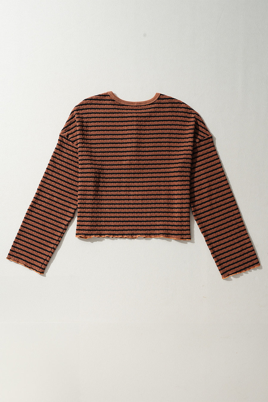 Textured henley stripe knit top in caramel with black stripes and lettuce hem detail.