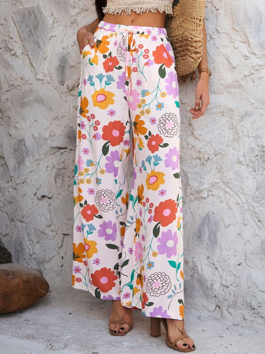 Geometric print wide-leg trousers with drawstring waist and pockets in multicolor floral pattern.