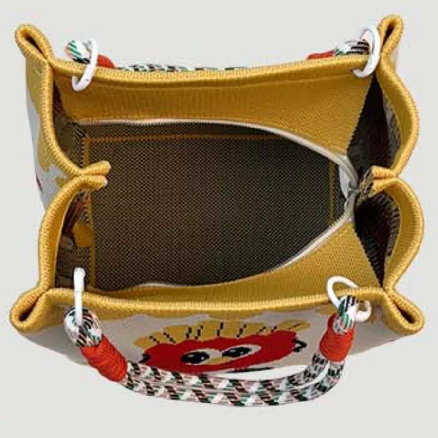 Yellow cartoon graphic tote handbag with red eye design and rope handles.