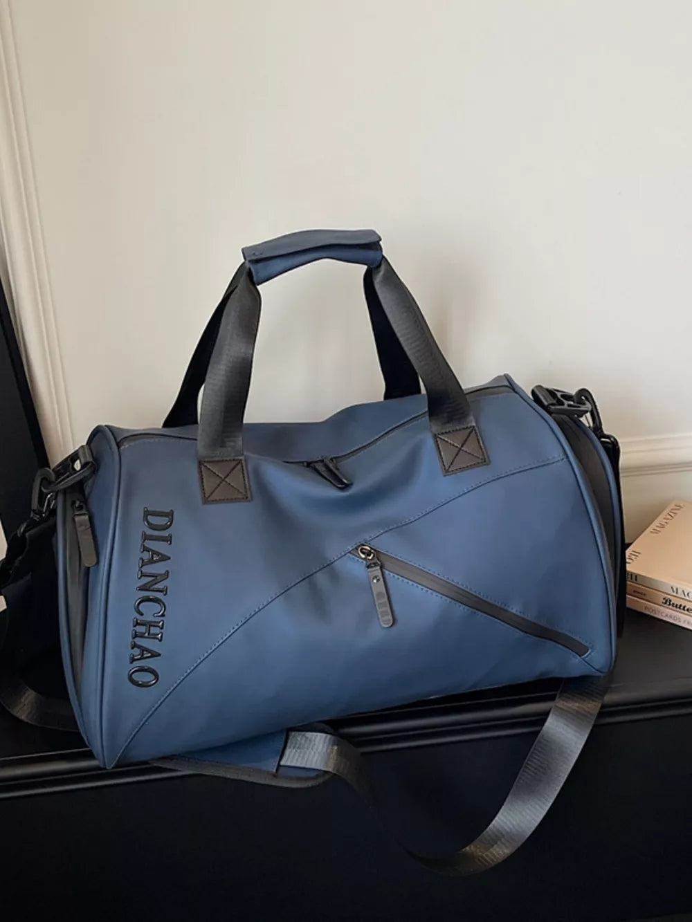 Blue travel organizer bag with padded strap and zippered pockets.