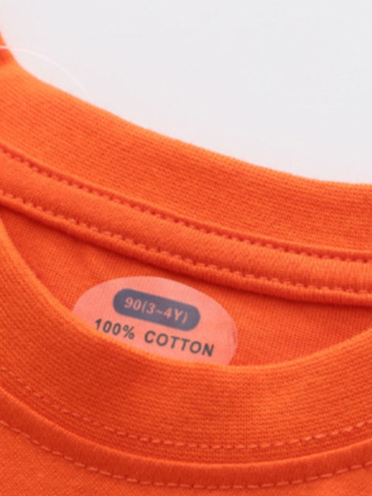 Orange cotton crew neck toddler t-shirt with size and material tag detail