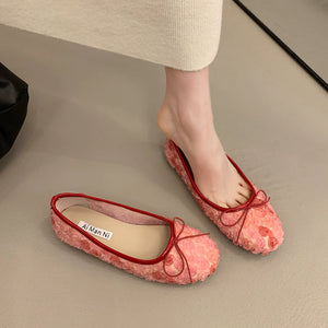 Pink floral bow slip-on flats with red trim and 3D texture.