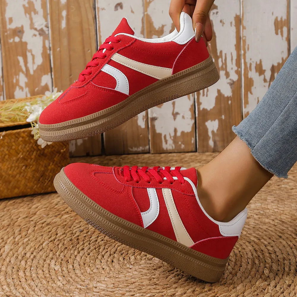 Red suede platform sneakers with curved cream and white stripes and gum soles.