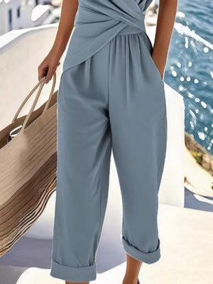 Blue twist-front V-neck top and pants set with cuffed hems and pockets.