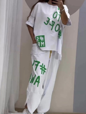 White graphic tee and drawstring pants set with bold green lettering and numbers.