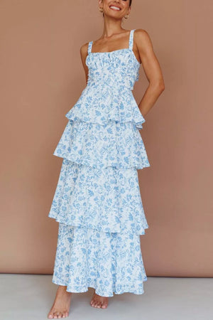 Tiered maxi dress with a blue floral print on white, square neckline, and spaghetti straps.