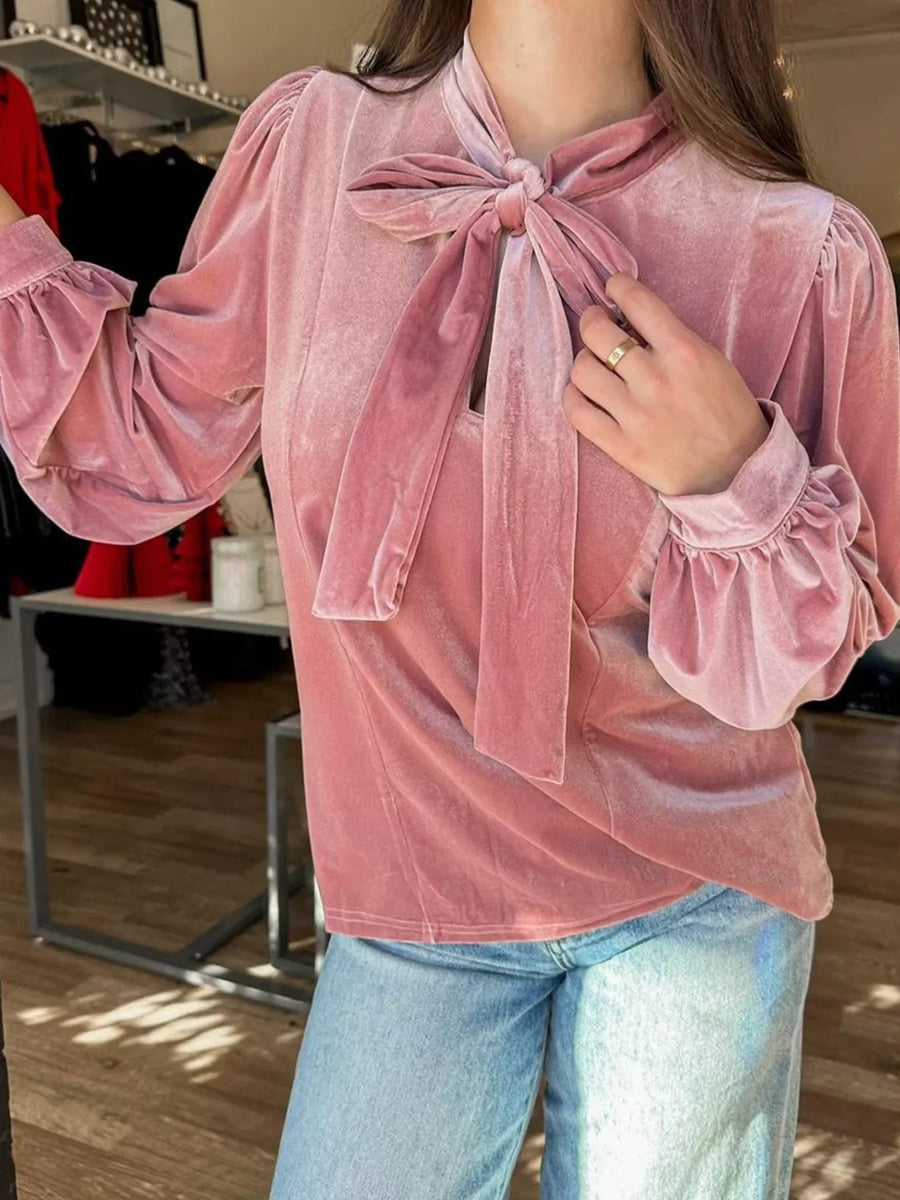 Dusty pink velvet blouse with tie-neck, puff sleeves, and ruffled cuffs.