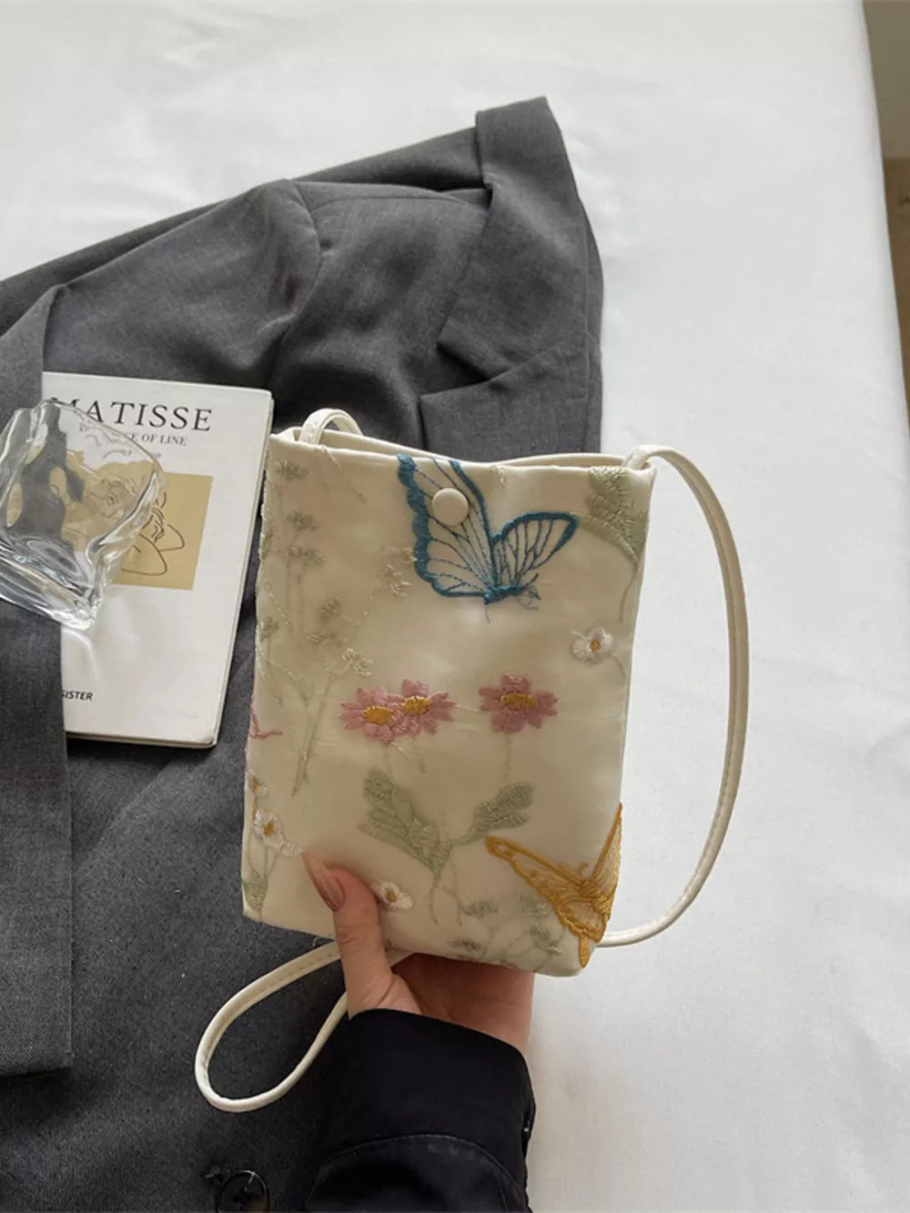 Off-white mini crossbody bag with delicate floral and butterfly embroidery