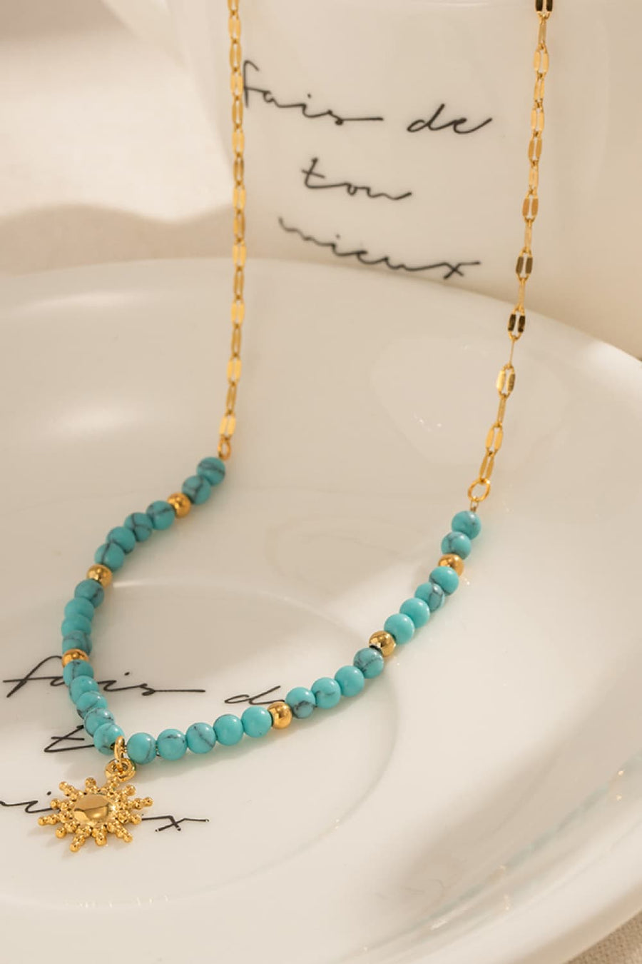Gold celestial sunburst beaded necklace with turquoise beads and gold accents