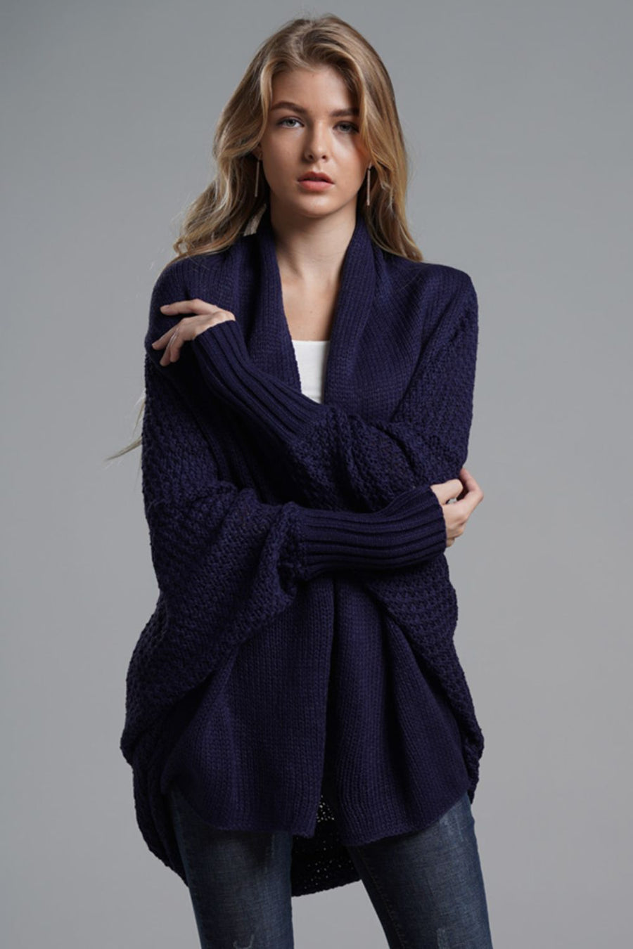 Navy batwing knit cardigan with drape front and textured sleeves.