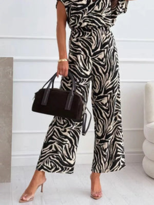 Chic zebra print wide-leg romper with cap sleeves and a cinched waist.