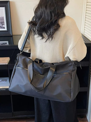 Spacious grey Oxford cloth travel duffle bag with black straps and zippered pockets.