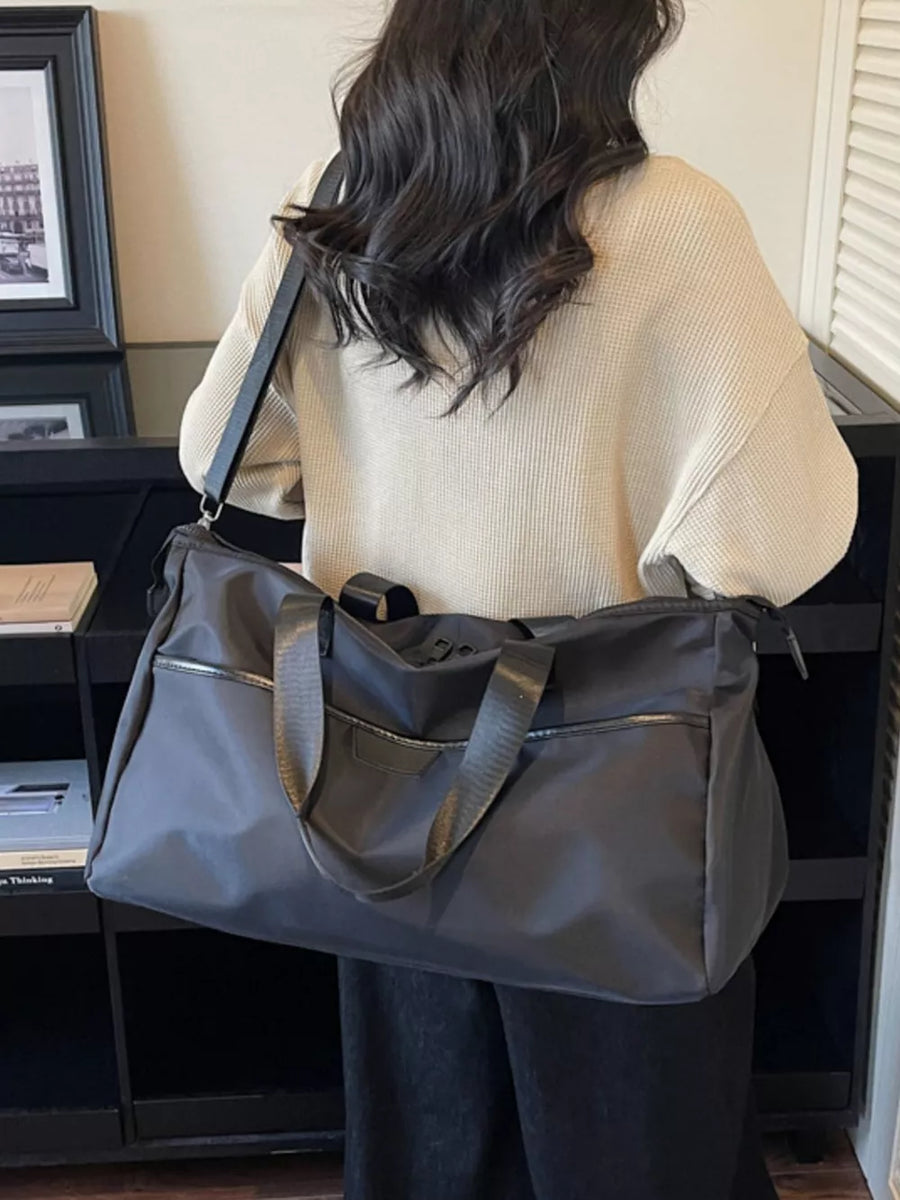Spacious grey Oxford cloth travel duffle bag with black straps and zippered pockets.