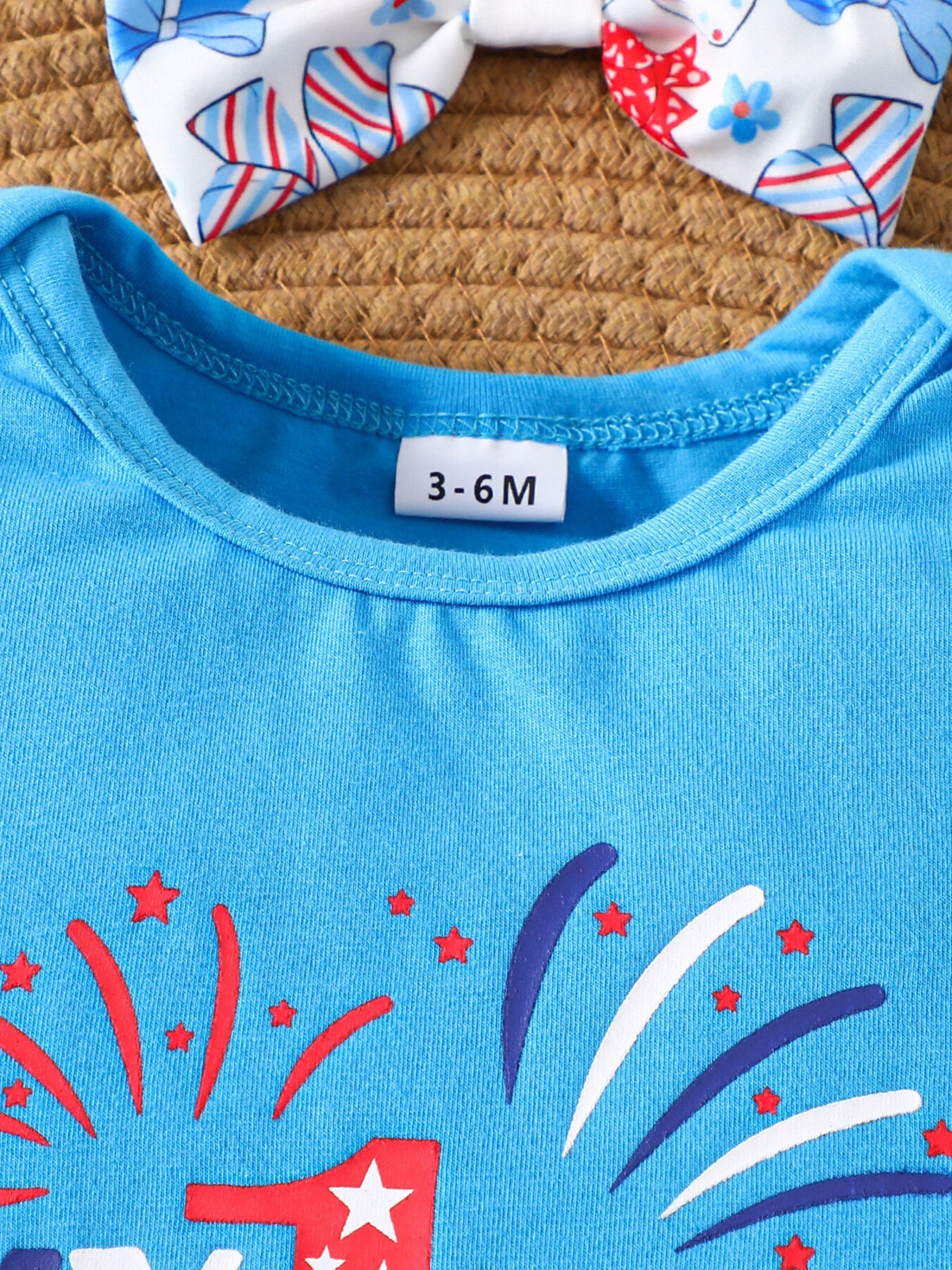 Blue cotton baby outfit with fireworks and stars print and matching bow headband.