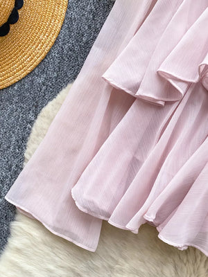 Pink chiffon blouse with tiered ruffled details and a textured weave.