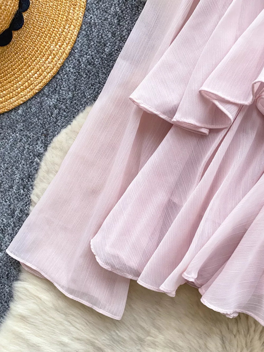 Pink chiffon blouse with tiered ruffled details and a textured weave.